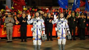 (Chinese astronauts Jing Haipeng, right, and Chen Dong, left, wave farewell to the crowd before getting on Shenzhou 11 on Oct. 17, 2016.)